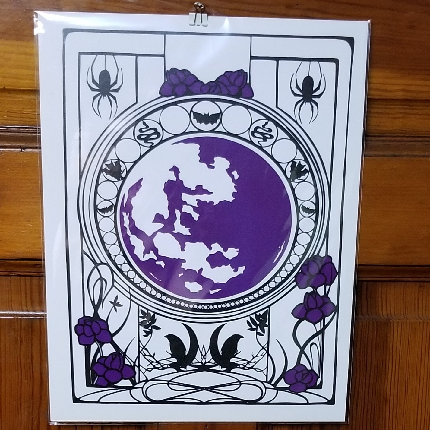 Print on heavy white stock, set vertically. Black spiders and crows on crescent moon, bats, snakes. Violet flowers and full moon. Image is a copy of paper cut silouhettes. It is very clean and moody.