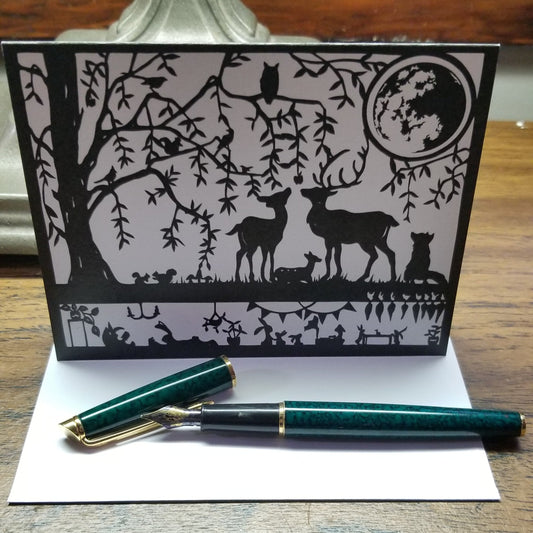 black and white forest scene. Features full moon, deer, fox, owl, squirrels, rabbits, and a willow tree.  the world beneath the forest is in view and we see a bunny home, complete with kitchen table and carrots. Some bunnies are reading a book and relaxing.