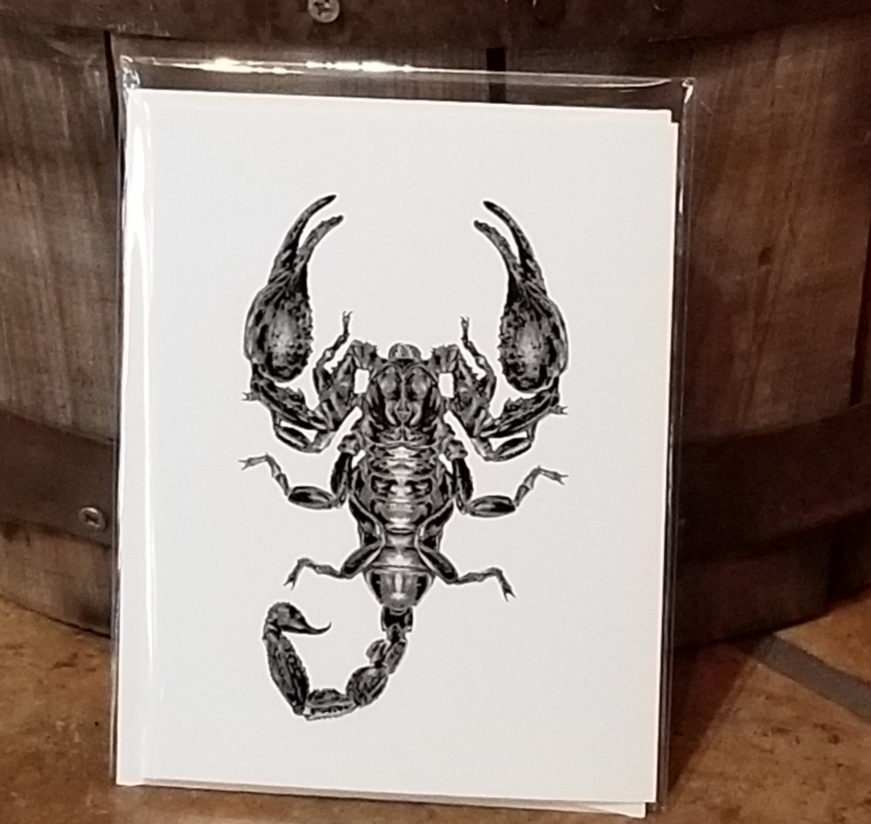 white card, blank inside. black metallic embossed scorpion illustration on front. 