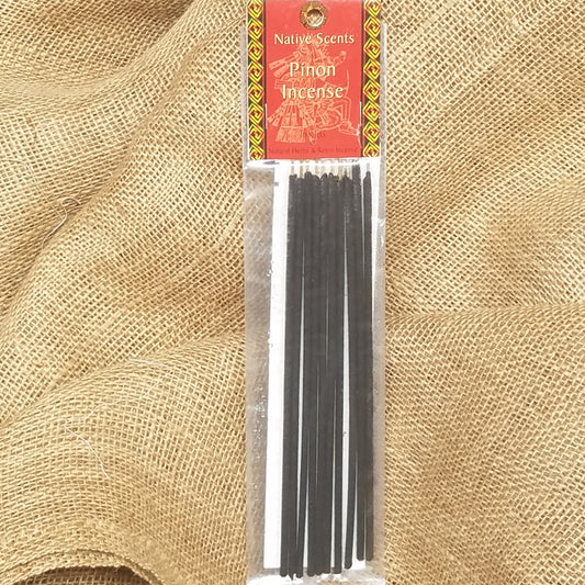 10 pack of dark incense sticks in clear celophane package with red and gold label. Background is burlap.